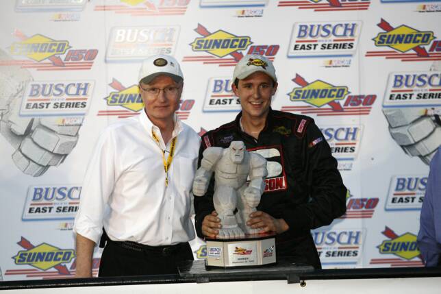 Driver holding a racing trophy